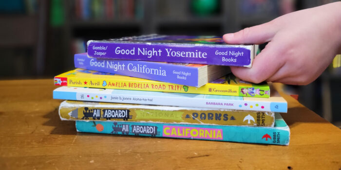 A stack of travel-themed books for young readers.