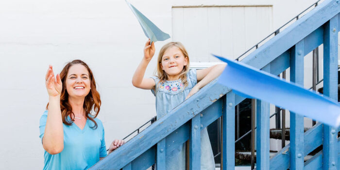 Flying paper airplanes with a mother and daughter.